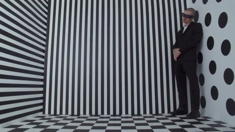 A man with digital goggles standing in the corner of a room Stock Footage 258186296