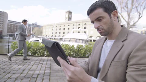 Man with digital tablet handheld device outside outdoors in the city Vídeo Stock 32720336