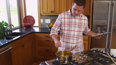 Man with digital tablet in kitchen cooking Video stock 62283924