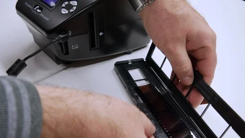 A man digitizes a camera film on a device Vidéo 99600414