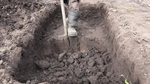 Man digs a deep pit. Digging a pit by shovel. Stock Footage 160568327