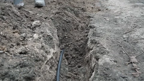 Man digs a ditch in the ground with a shovel Stock Footage 266806485