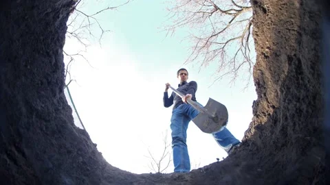 A man digs a hole in the ground Stock Footage 132813837