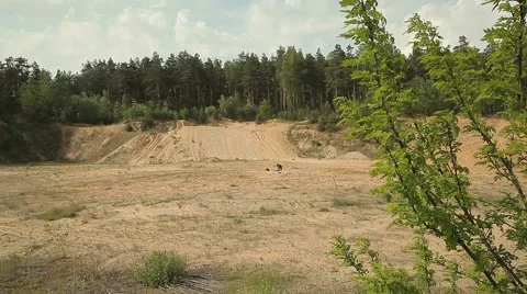 A man digs a hole in the midst of the wasteland. forest around. Panoramic view Stock Footage 58192065