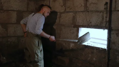 The man digs the sawdust. General plan, natural light, indoors, in a village on Stock Footage 98502806