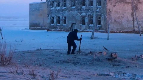 Man digs snow with a stick Video stock 99504375