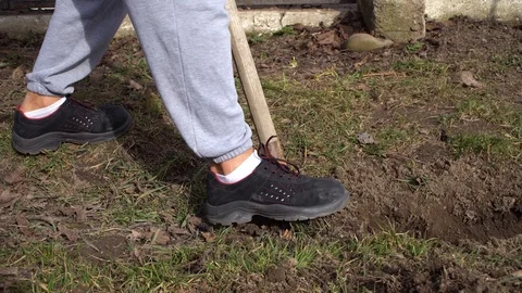 The man digs a trench, the man digs the ground with a shovel Stock Footage 125809555