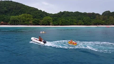 A man on a dinghy drags an inflatable wheel with a child Stock Footage 172414595
