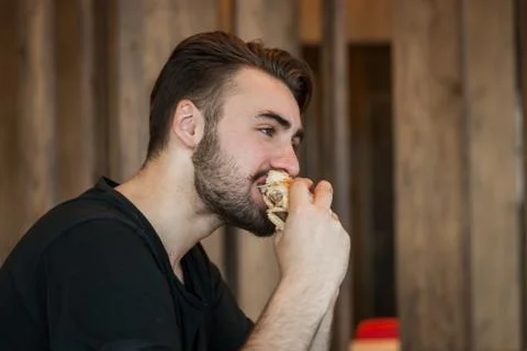 A man at dinner eats a burger Stock Photos