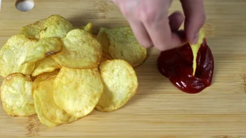 Man dips potato chips in red sauce in cafe Stock Footage 241729147