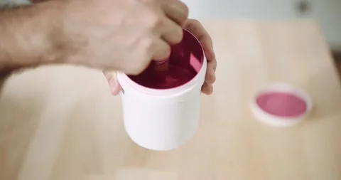 Man dips small brush into a can of pink paint Stock Footage 155796766