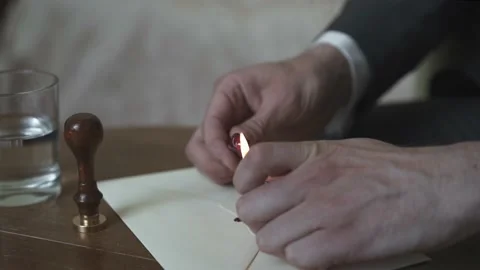 Man dips wax onto a letter using a lighter Stock Footage 171327039