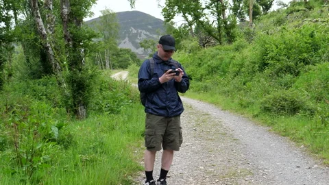 Man on dirt track is checking map on smartphone Vídeos de archivo 159749288