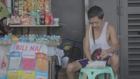 A man with disability eating while watching his store Stock Footage 230089223