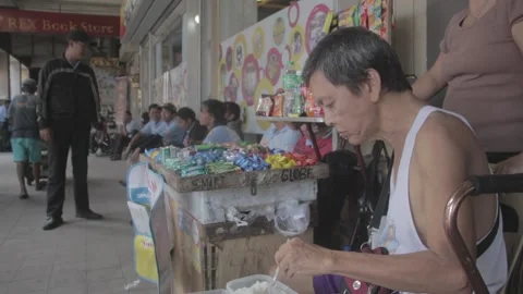 A man with disability eating while watching his store Stock Footage 230089450