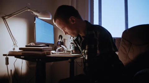 Man With Disability Prepares for Work at Desk, Wearing Glasses Stockbeeldmateriaal 321938161