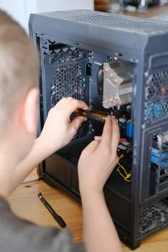 A man disassembles a computer system unit with a screwdriver Stockfoto's