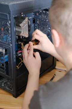 A man disassembles a computer system unit with a screwdriver Stockfoto's