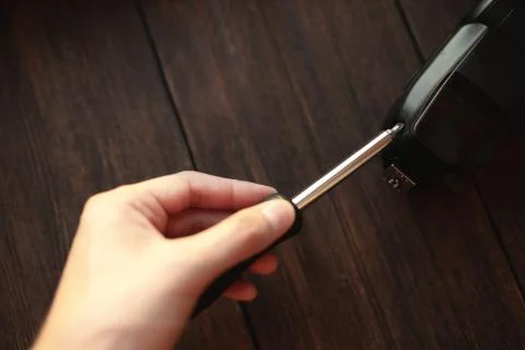 A man disassembles an electronic device with a screwdriver Stock Photos