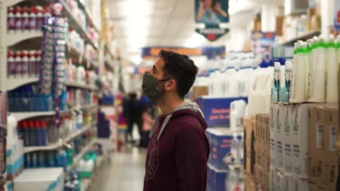 A Man In A Discount Store Thinks About Which Product To Buy During The Pandemic Stock Footage 149978379