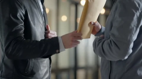 Man discreetly taking out envelope filled with money handing it to another man Stock Footage 304689029