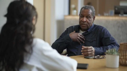 Man discussing his problems with physician in hospital Stock Footage 105599876