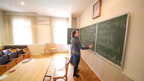 Man discussing with woman with pointer equations on blackboard. Video stock 69988885