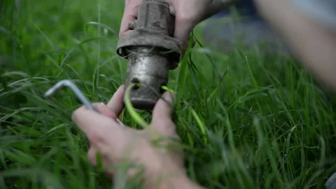 A man dismantles a lawn mower to replace spare parts Stock Footage 132860850