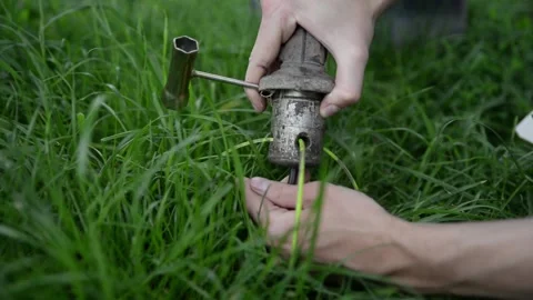 A man dismantles a lawn mower to replace spare parts Stock Footage 132860963