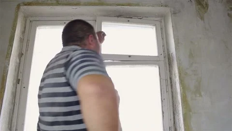 The man is dismantling the old window with his hands. Stock Footage 87644644