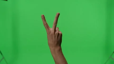 Man displaying hand gestures against a green screen background Stock Footage 312789685