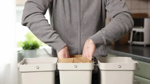 Man disposes of biowaste using paper bags, camera zooms in on action sequence Stock Footage 320249948