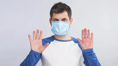Man distancing from camera wearing protection mask on face isolated on grey Stock Footage 127116545
