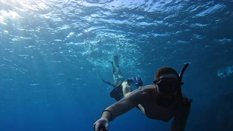 Man dive deep blue sea and taking cool selfie with sun rays through water 스톡 동영상 186676797