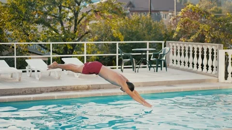 A Man Dive into a Refreshing Pool Stock Footage 290030890