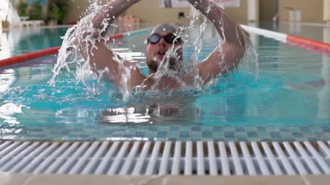 Man dives backwards in the pool and swims under water Stock Footage 145756368