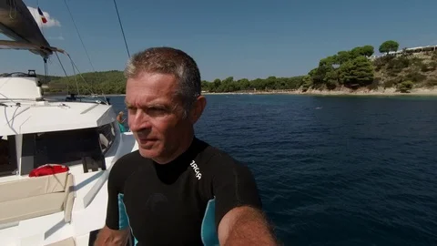 A man dives from the bow of a sailing catamaran Stock Footage 95833746