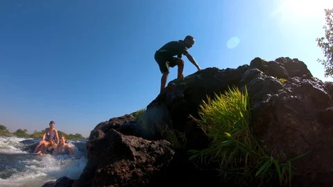 A man dives into Devil's Pool, the edge of Victoria Falls, Zambia close to the Stock Footage 113200677