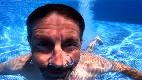 Man dives into pool and bumps into underwater camera Stock Footage 201360222