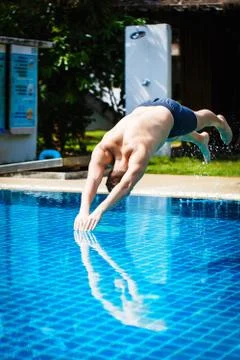 Man dives into pool 스톡 사진