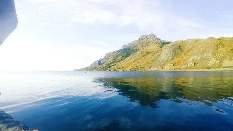 A man dives into the sea against the backdrop of the mountains Stock Footage 79103198