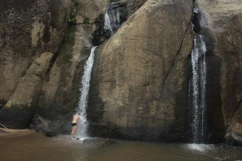 A man dives under a waterfall in the countryside of minas gerais state in Brazil Stock Photos