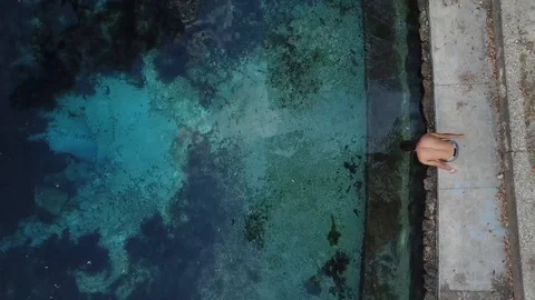 Man Diving into Clear Blue Pool Drone Birds Eye Stock Footage 88962708