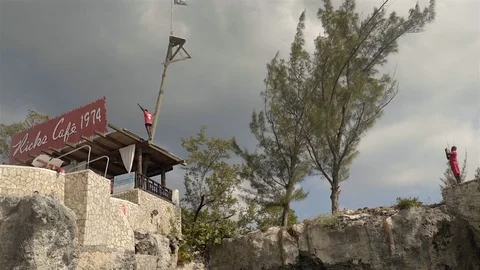 Man diving of a cliff at Ricks Cafe in Negril Jamaica. 4K UHD. Stock Footage 72950470