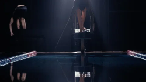 Man diving off a diving board into a swimming pool at night Stock Footage 275262655