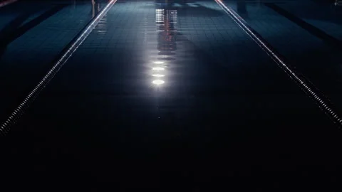 Man diving into a lit up swimming pool at night Stock Footage 275262289