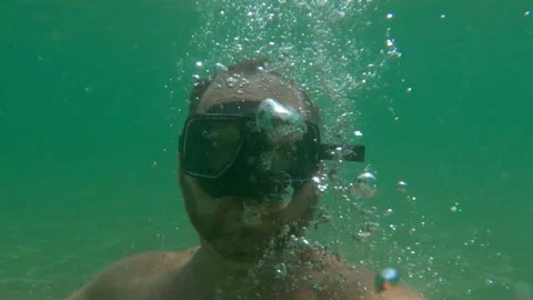 Man with diving mask creating bubbles underwater, slow motion 動画素材 278840477