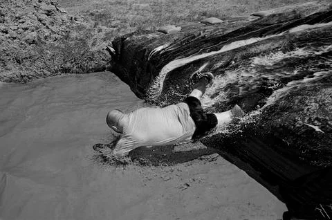 Man diving in a pool of mud Stock Photos