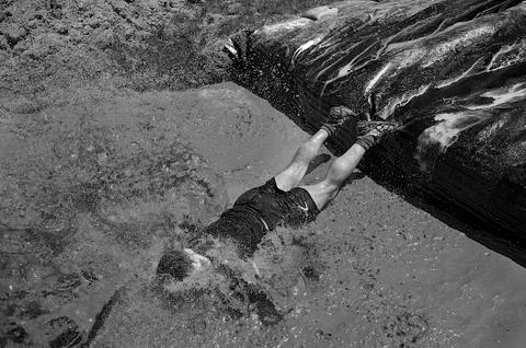 Man diving in a pool of mud Stock Photos