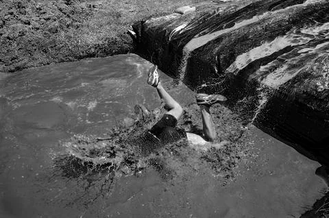Man diving in a poool of mud Stock Photos